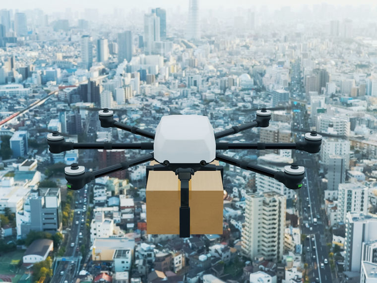 Eine Transportdrohne fliegt über eine Großstadt.