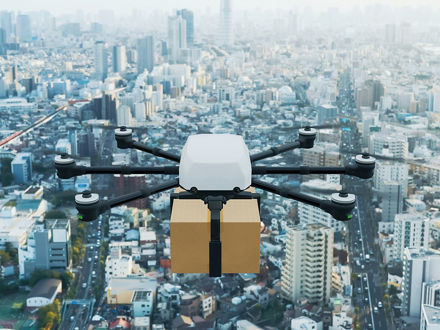 Eine Transportdrohne fliegt über eine Großstadt.