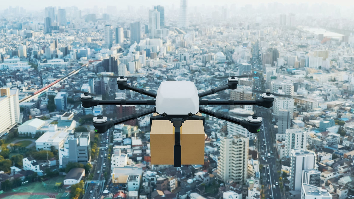 A transport drone flies over a big city.