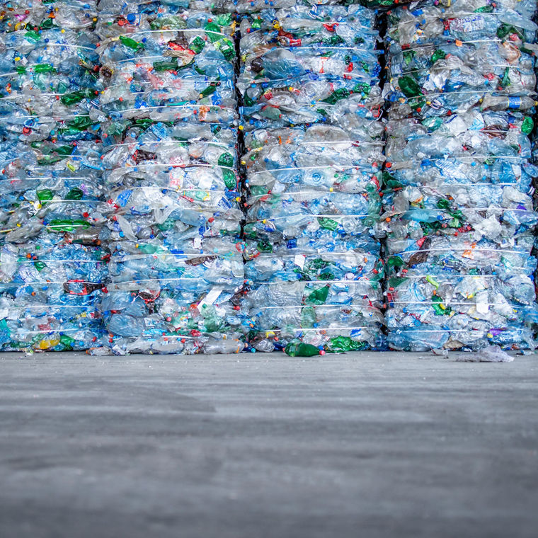 A large pile of plastic PET bottles, compressed and ready for recycling.