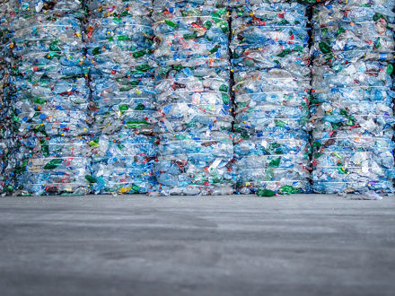 A large pile of plastic PET bottles, compressed and ready for recycling.
