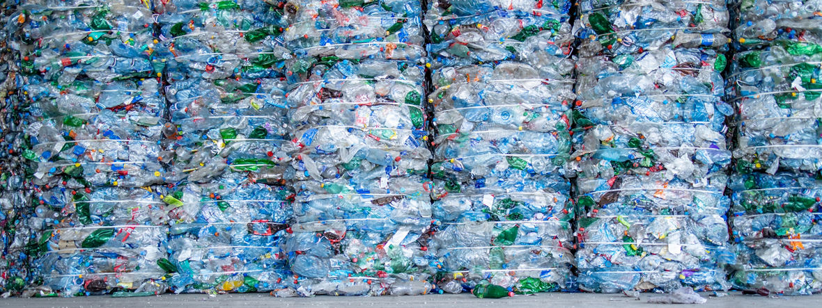 A large pile of plastic PET bottles, compressed and ready for recycling.