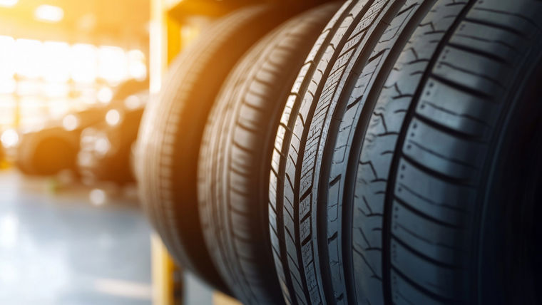 Closeup of new car tires on a rack in a shop, ready for sale.