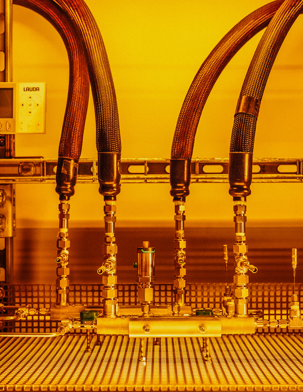 Vier Schläuche führen auf jeweils einen Steckkontakt. das Bild ist in warm-gelb aufgenommen.