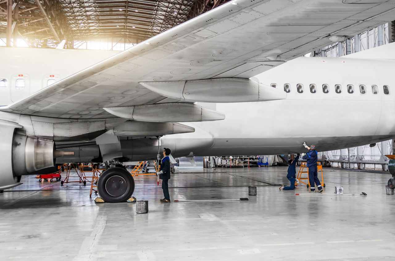 'Several people wash an airplane in the hangar Mehrere Personen waschen ein Flugzeug im Hangar  Several people wash the aircraft in the hangar for maintenance# view of the chassis# wing and tail'