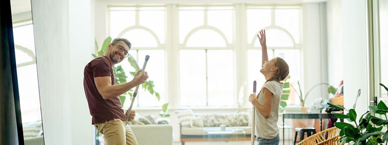 Shot of a handsome mature man and his daughter mopping the floors in their home as part of their spring cleaning