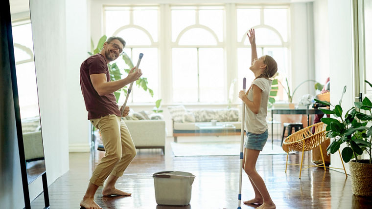 Shot of a handsome mature man and his daughter mopping the floors in their home as part of their spring cleaning
