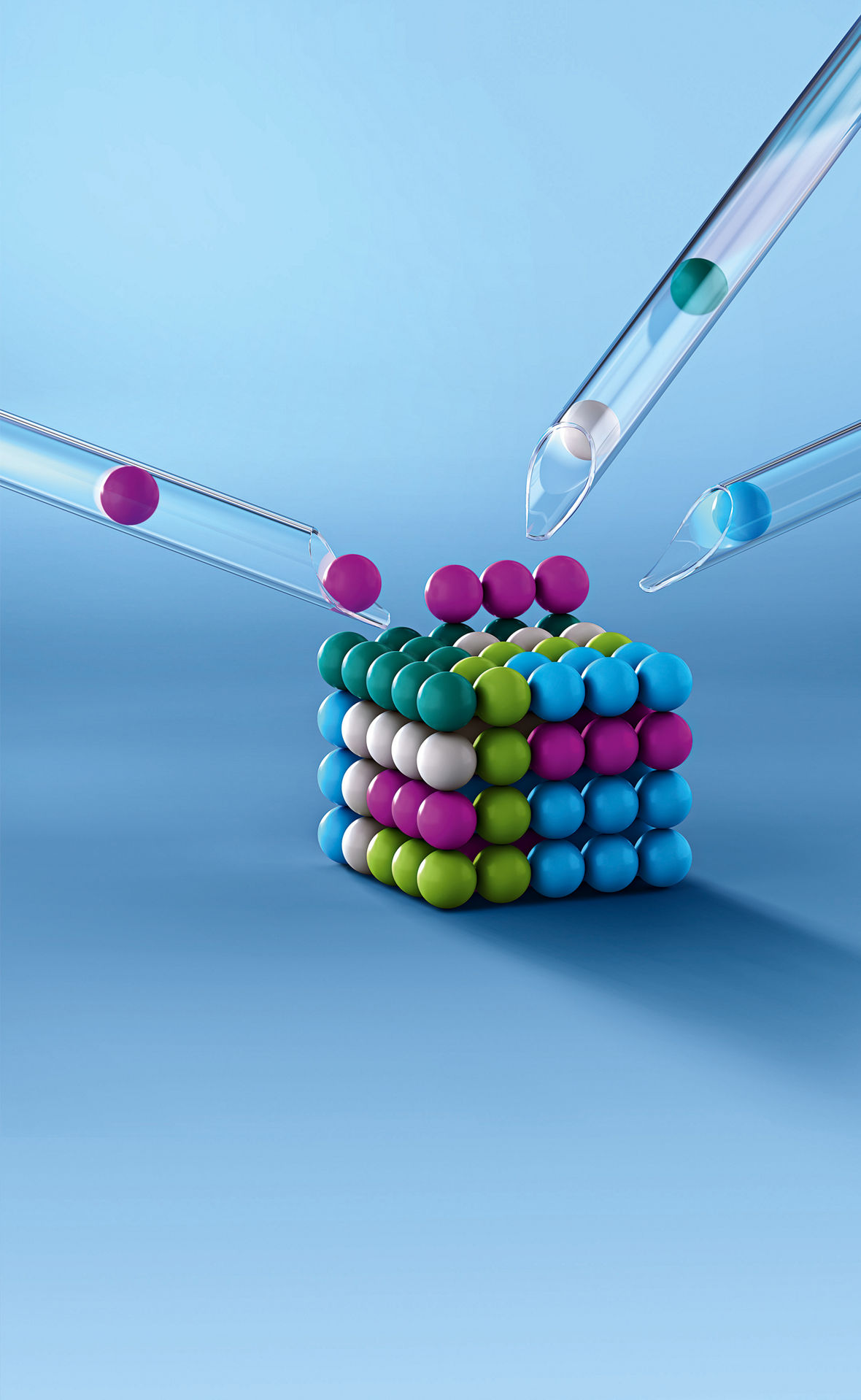 An image shows an arrangement of colorful spheres formed into a cube. Four pipettes with colored spheres in purple, green, and blue are directed at the cube and appear to be placing spheres on it. The background is light blue.