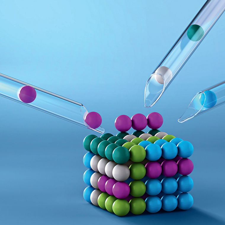 A cube made of colorful balls. Additional balls are added from three glass tubes."
