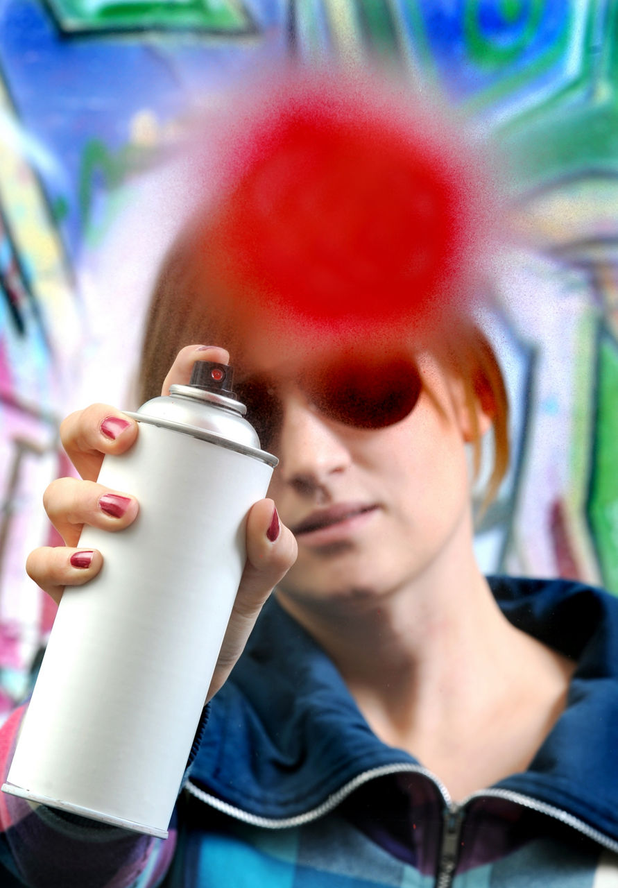 A woman sprays a red dot.