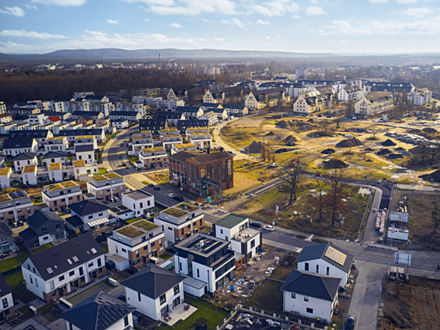 Aerial view of the site, with buildings at the edges and a clear area in the center.