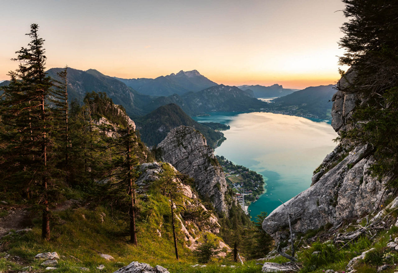 Blick von einem Berg auf den Attersee bei Dämmerung.