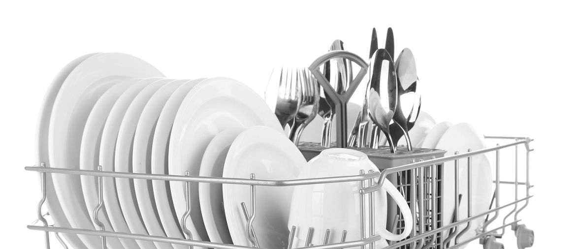 Clean dishes drying on metal dish rack, isolated on white