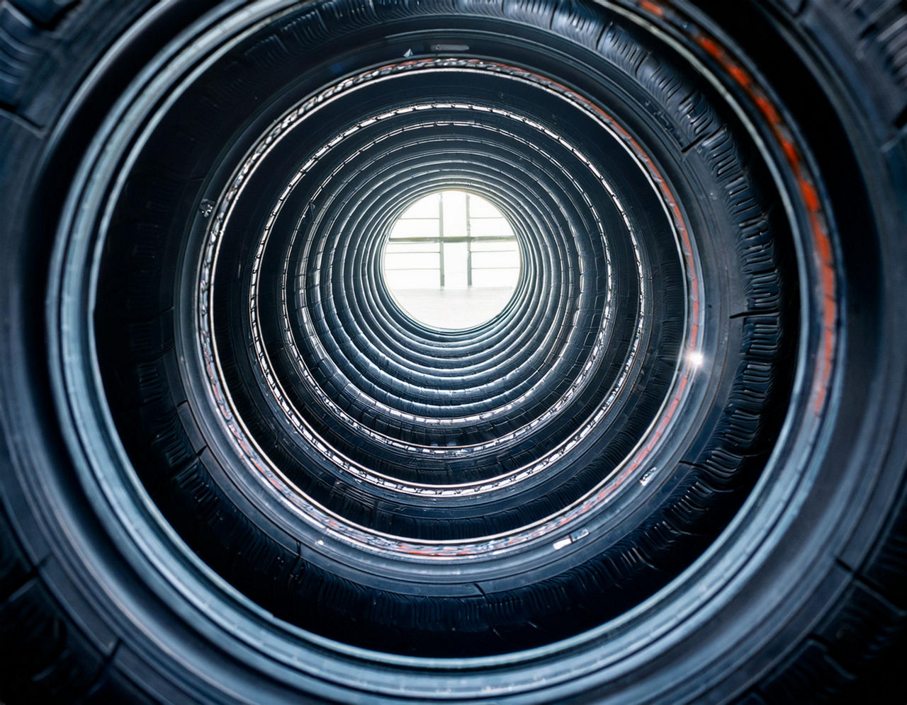 A long row of car tires, view through the middle (AI-generated image)