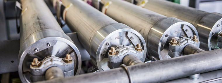 Close-up of industrial metal cylinders with connected pipes and fittings.