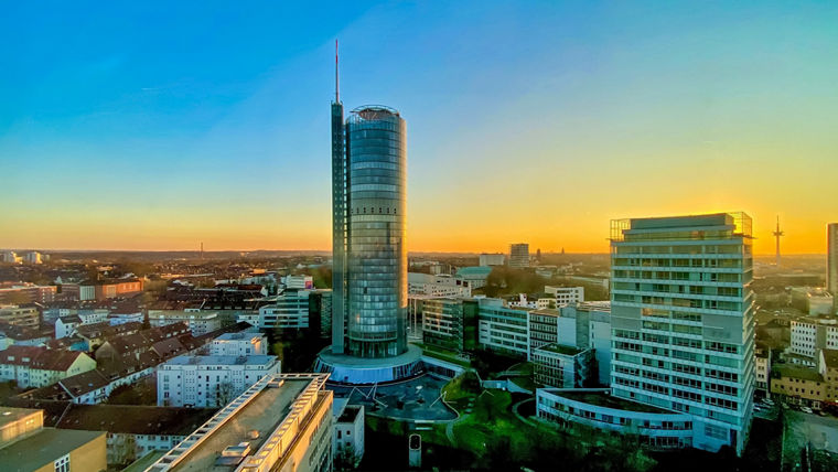 Stadtpanorama Stadt Essen mit einem markanten, runden Hochhaus im Zentrum. Hierbei handelt es sich um den Evonik Tower.