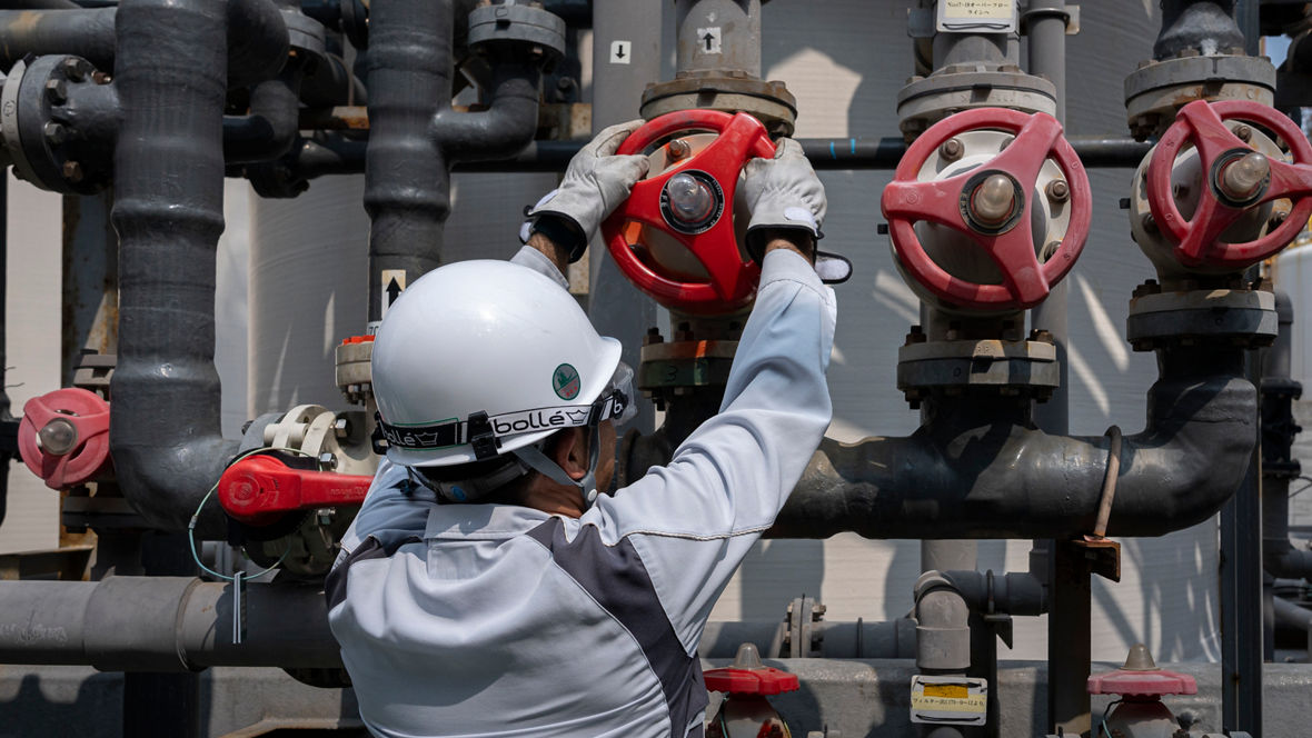 An Evonik employee turns a valve wheel.