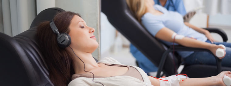 Patient listening music while being transfused in hospital ward
