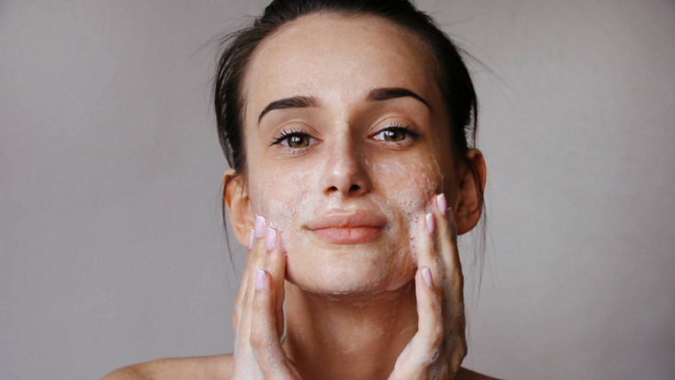 Woman cleaning face with foam