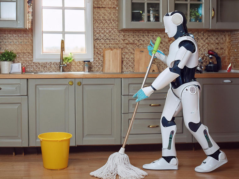 Ein humanoider Roboter wischt in einer Küche den Boden.