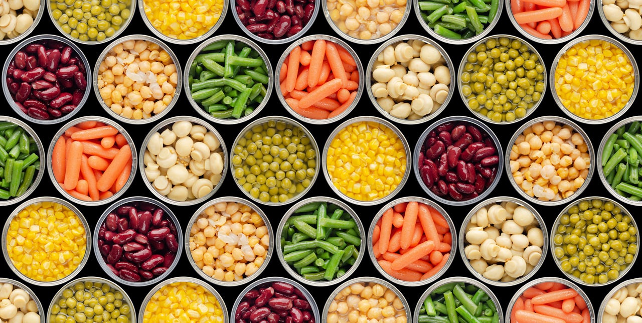 Seamless food background made of opened canned chickpeas, green sprouts, carrots, corn, peas, beans and mushrooms on black background