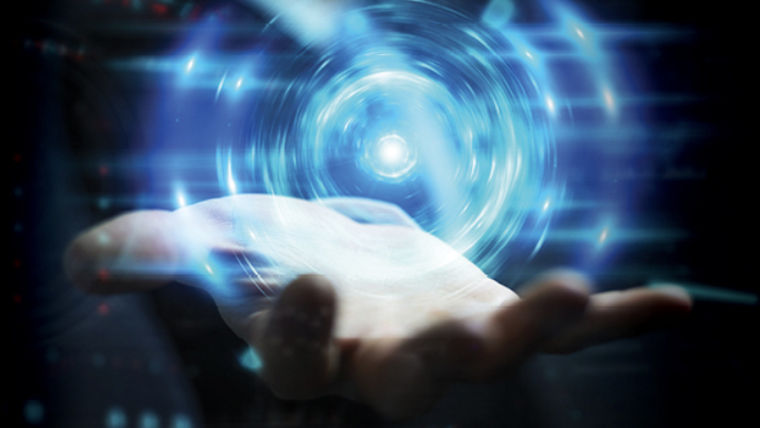 A hand holding a glowing, swirling blue light orb with digital effects in the background.