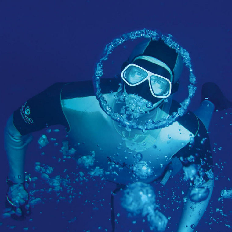Herbert Nitsch taucht und blickt in die Kamera. Um sein Gesicht ist eine kreisförmioge Luftblase.