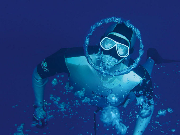 Herbert Nitsch taucht und blickt in die Kamera. Um sein Gesicht ist eine kreisförmioge Luftblase.
