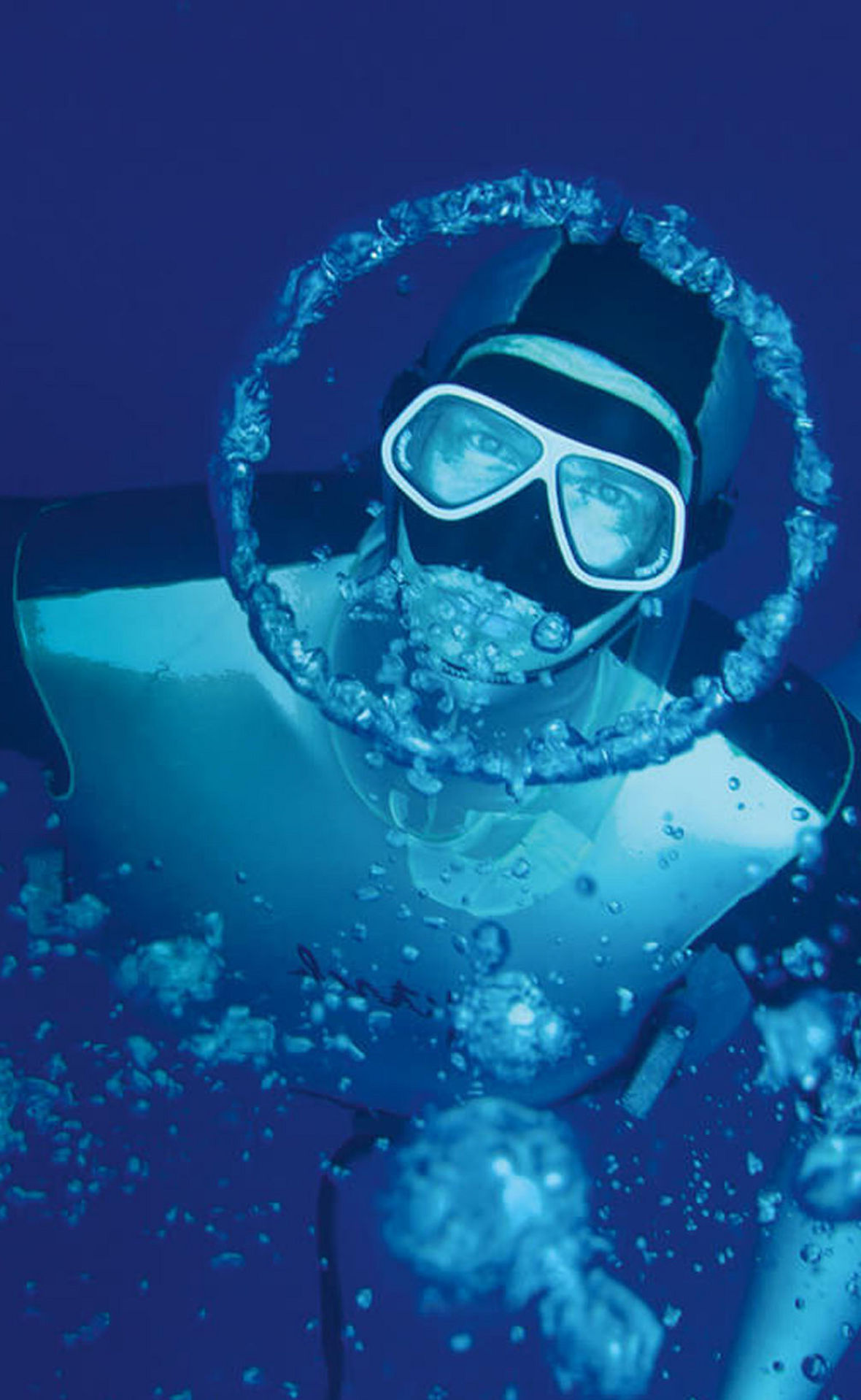 Herbert Nitsch taucht und blickt in die Kamera. Um sein Gesicht ist eine kreisförmioge Luftblase.