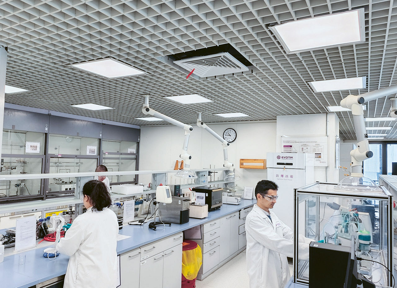 Drei Personen arbeiten in einem hochmodernen Labor.