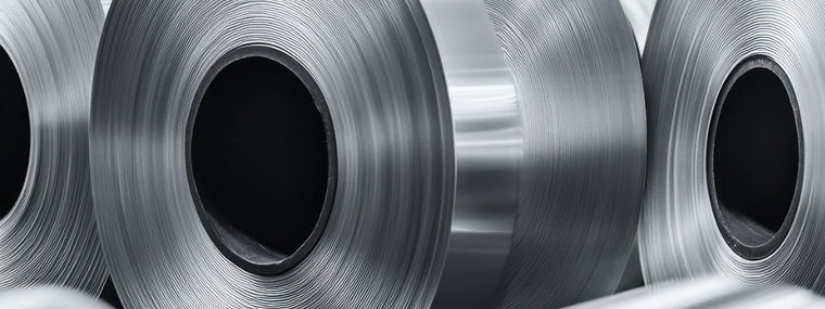 A close-up shot showcasing rows of shiny aluminum coils in a factory, highlighting industrial production, metal material, and a sleek, silver tone.