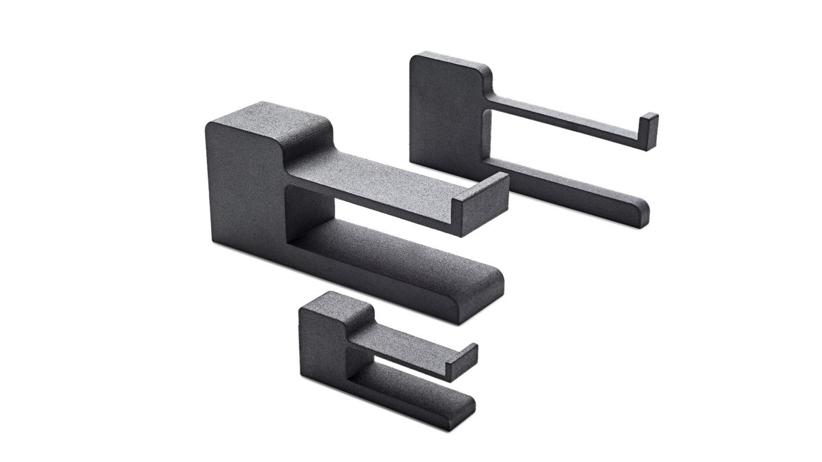 Three black 3D-printed industrial parts with precise geometry, manufactured from INFINAM® PA12 powder using Multi Jet Fusion (MJF) technology.