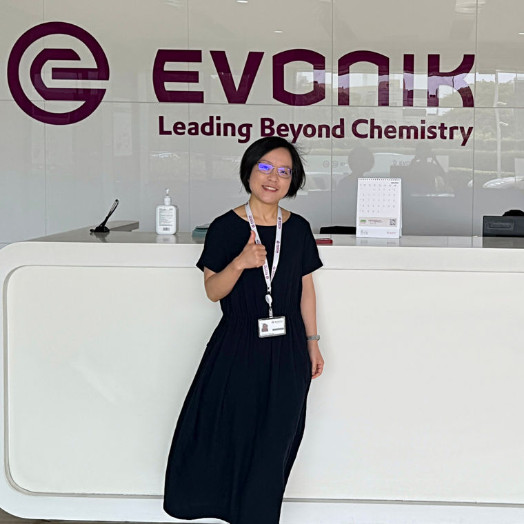 Reception area at Evonik, featuring the logo and a welcoming atmosphere with a staff member.