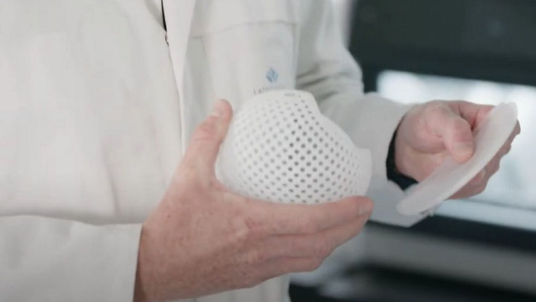 Zwei Hände halten den gewölbten und den flachen Teil es Implants nebeneinander.