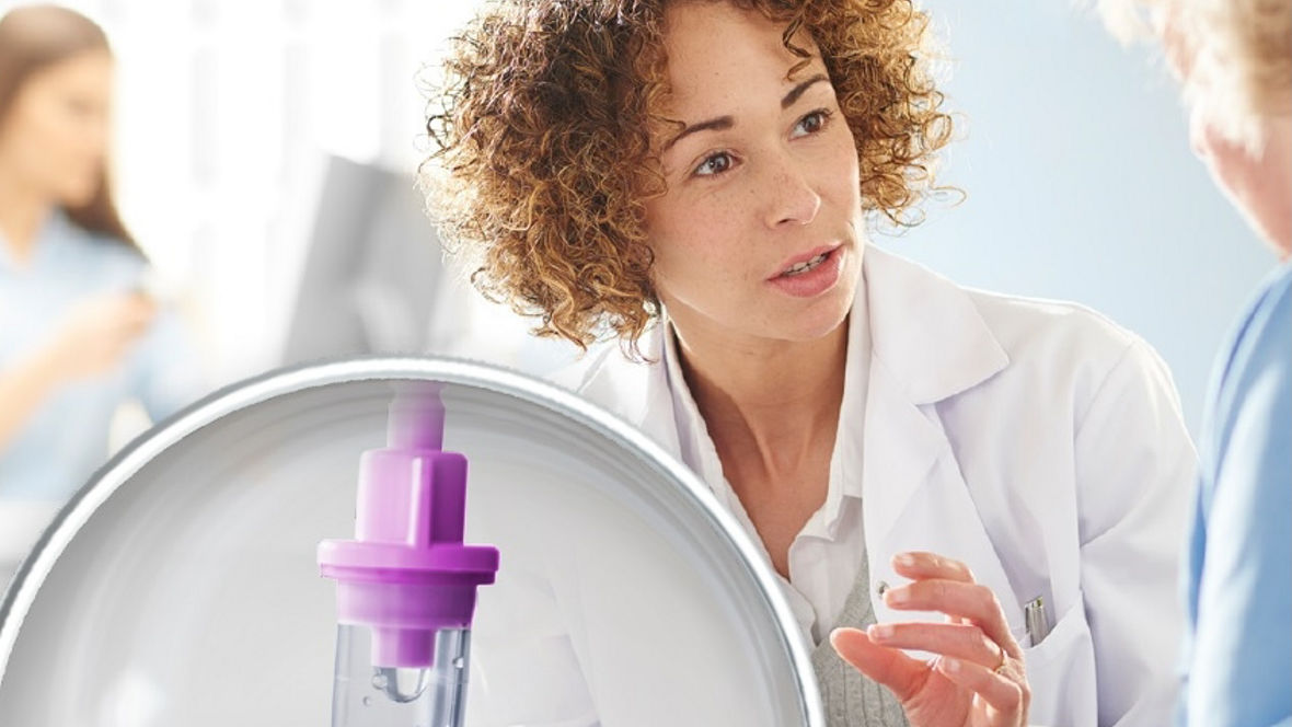 A healthcare professional in a white coat engages in a discussion with a patient, while a close-up of a Vestamid medical device with a purple component is displayed in the foreground, highlighting its design and purpose in patient care.