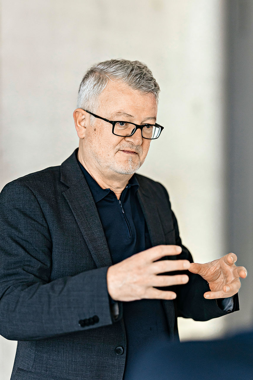 Maximilian Fichtner, gray-haired and wearing glasses, gesticulates with both hands.