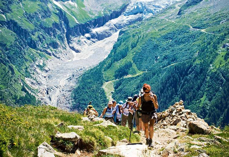 Eine Gruppe Wanderer auf einem schmalen Pfad in den französischen Alpen.