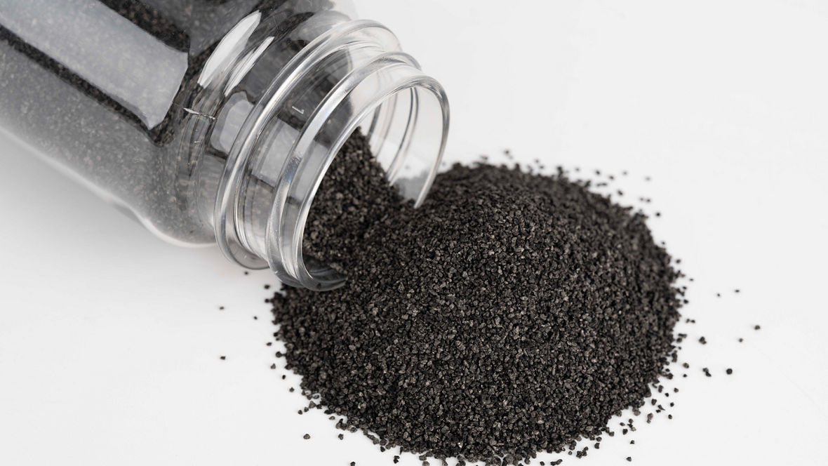 Braune Krümel, die aus einer Glasflasche rieseln.