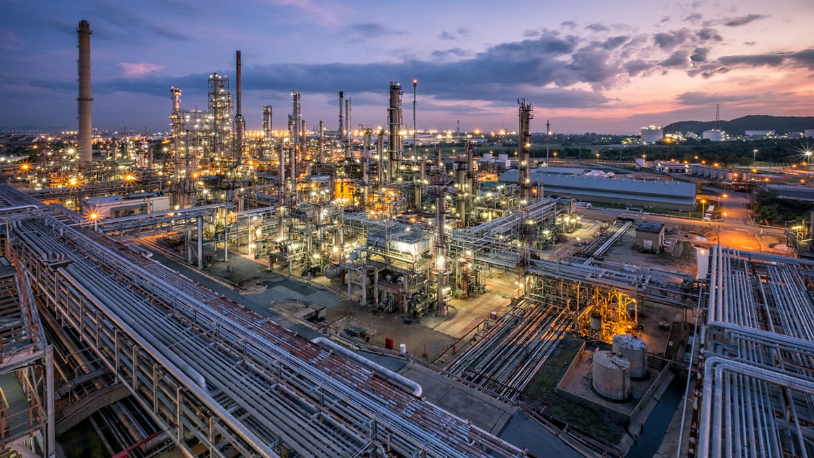 Oil refinery with pipeline and distillation tower during sunset in Chonburi, Thailand