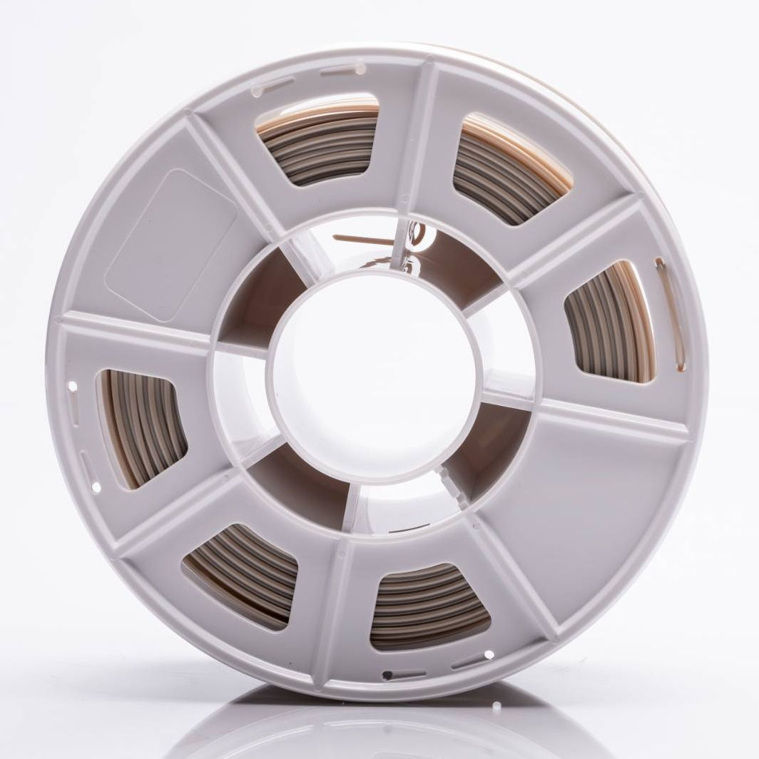 Close-up view of a gray plastic spool with multiple compartments, containing neatly wound filament or wire, photographed against a white background.