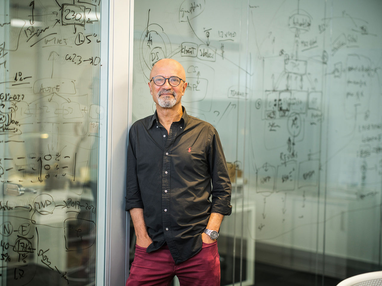 Ismael Darwish lehnt an einer Glaswand. Hinter ihm sind Formeln an die Wand geschrieben.