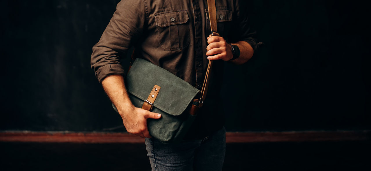 Man with duffle bag on shoulder. leather and canvas bag