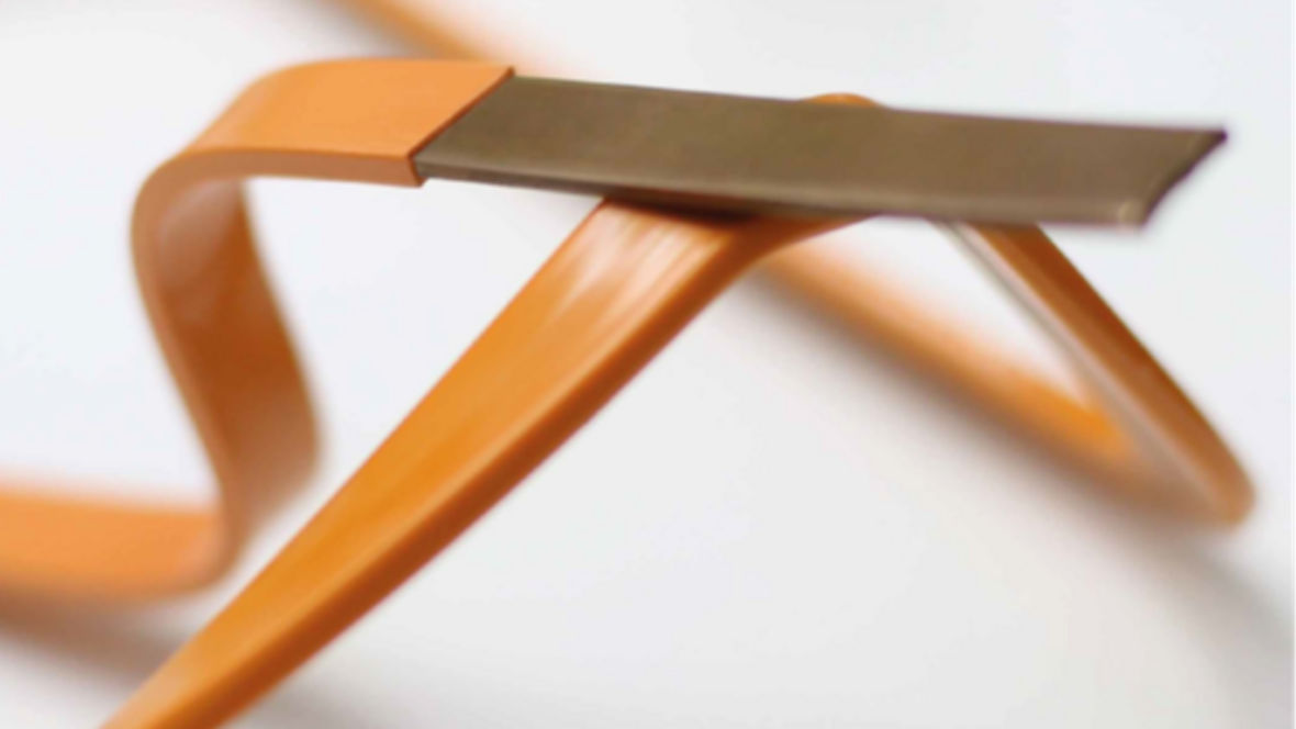 Close-up of a flexible orange plastic strip with a flat metallic tip on a white background.