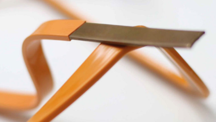 Close-up of an orange-coated power busbar, showcasing its sleek design and durable metal strip, highlighting its application in electrical distribution systems.