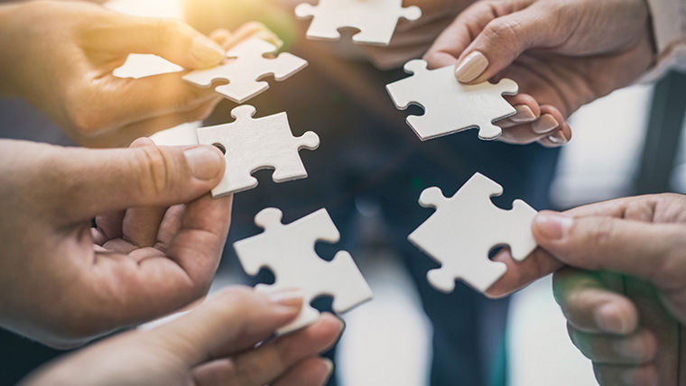 A group of business people assembling a jigsaw puzzle
Eine Gruppe von Geschäftsleuten, die ein Puzzle zusammenbauen