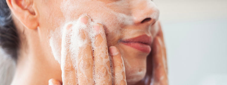 Woman washing her face with foaming product