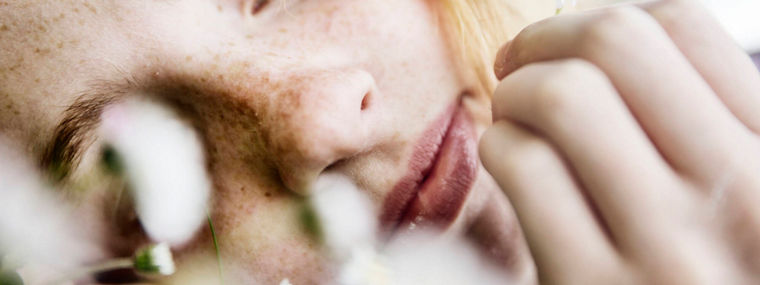 Girl holding daisy in her hand, close-up