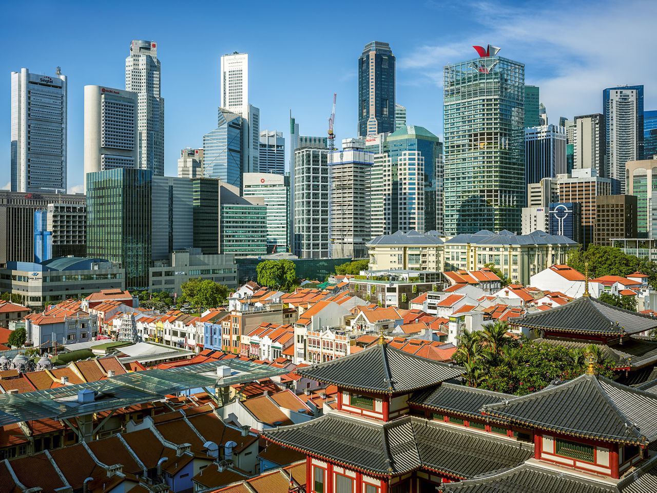 Blick über Pagodendächer auf eine Hochhaus-Skyline.
