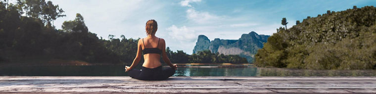 woman meditating at lake