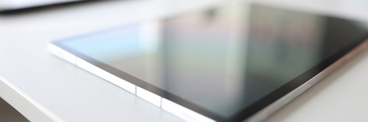 Modern digital tablet lies on table in background. Doing business online closeup